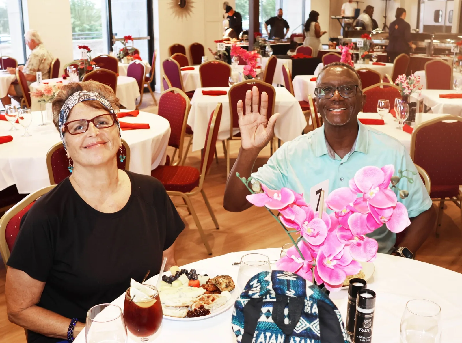 Guests at a Sunday brunch table with orchids and plates in the dining room at The Venue Clermont